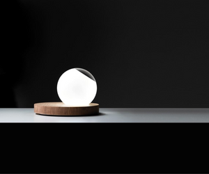 Omar Carragli Design for Davide Groppi Wood - Glass Table lamp with dimmer Pigreco is rigorous in its design, putting together two essential, concrete and tangible materials: wood and glass. The crystal ball, in part made of frosted glass, can be positioned as one desires, functioning both as diffusor and convex lens. 24 V DC LED 6,5 W - 450 lm Actual product may vary from images shown on website. Please contact info@rifugiomodern.com for finish samples.
